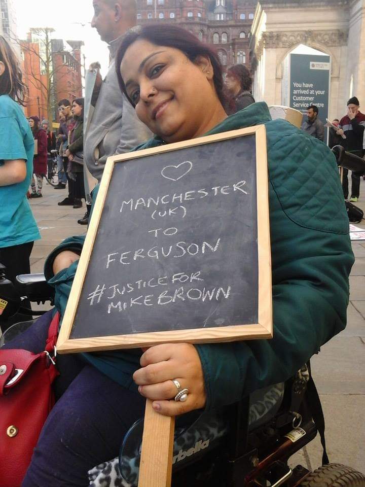 Manjeet holding a chalk placard stating: Manchester (UK) to Ferguson #JusticeForMikeBrown